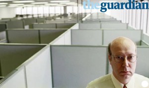 Older man sat in office with screens